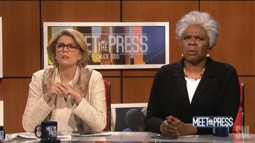 the two women are sitting at a news desk