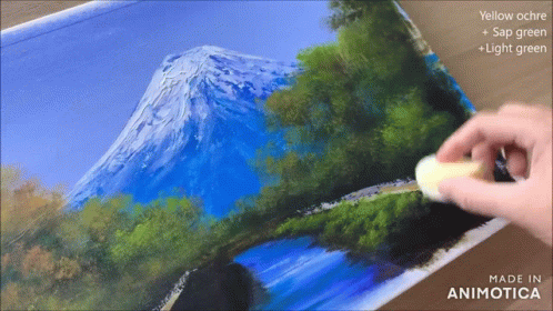 a man is painting a landscape with paints and brushes
