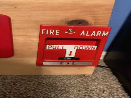 a fire alarm that is blue on the ground