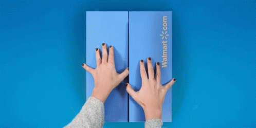 person with blue fingernails holding up two fingers in front of an orange box
