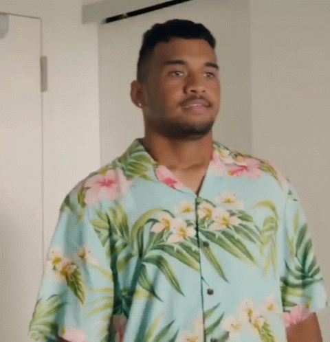 a man wearing a hawaiian shirt looks up