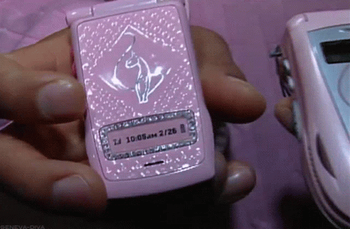 a person holding a pink cellphone with pink and white diamonds