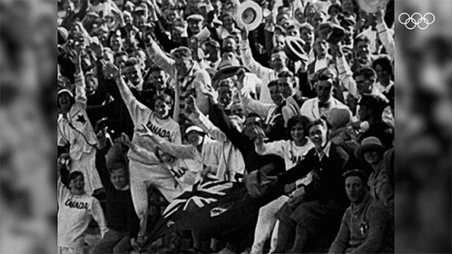 a large group of spectators is sitting on the seats of a baseball stadium and raising their hands in the air