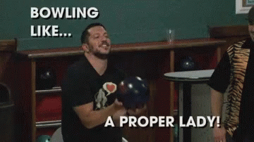 two men laughing as they hold up bowling balls