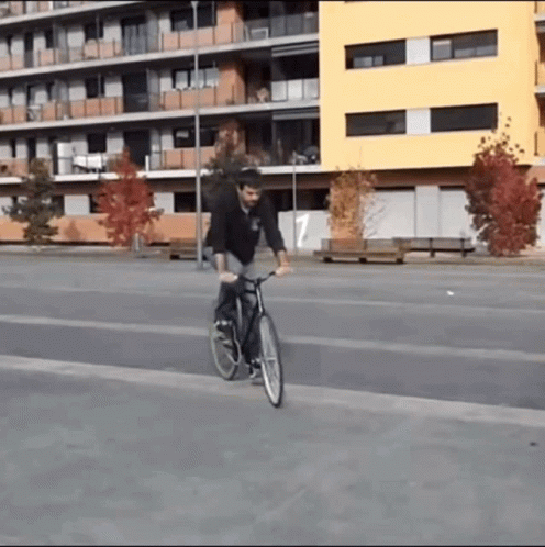 a young man riding his bike down the street