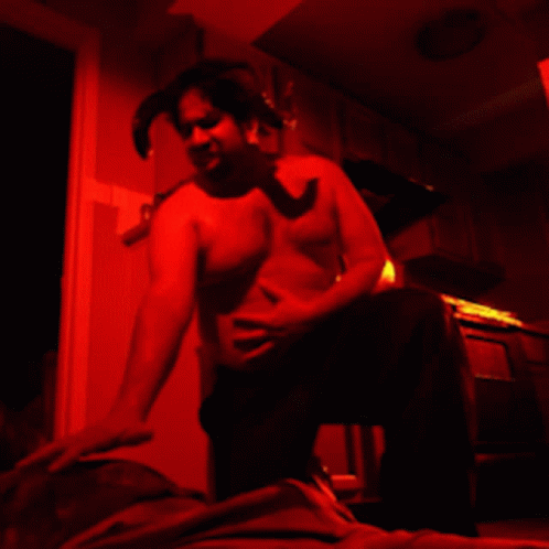 a man that is in the dark with a towel over his stomach