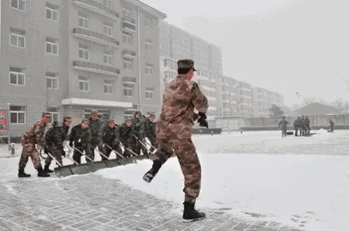 men walking in a line wearing uniform on a snowy street
