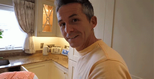 a man in a kitchen taking a selfie