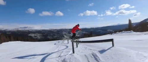 a snowboarder performs a jump off a railing