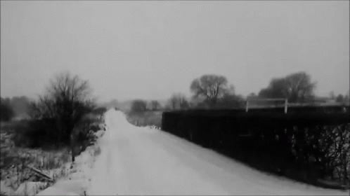 there is a black and white po of a snow covered road