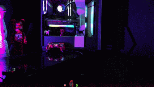 a computer tower on a desk illuminated with neon