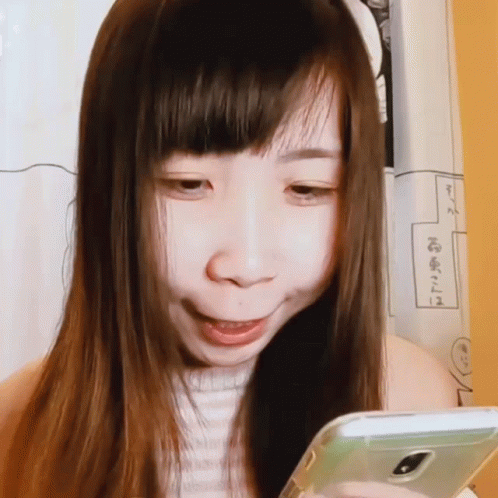 an oriental woman is using her phone while looking at it