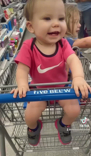 a baby with blue makeup in a shopping cart