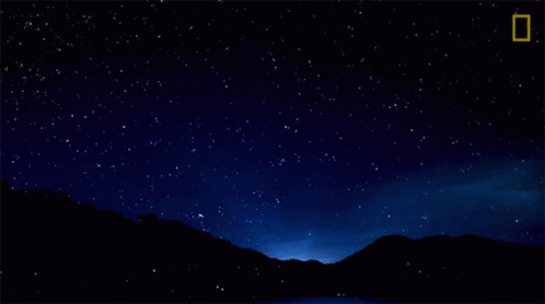 a view of the sky and mountains at night