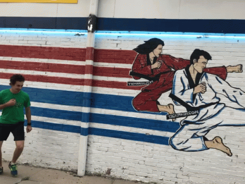an asian street mural depicts two women in white clothes, one man throwing the frisbee