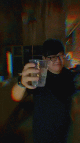 a person takes a selfie while holding a drink