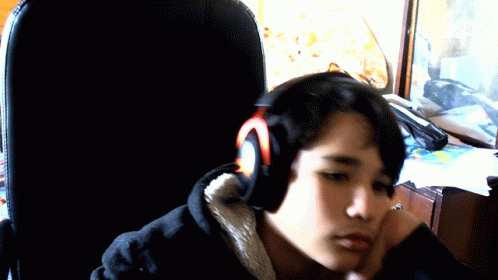 a person sitting in front of a laptop computer wearing headphones