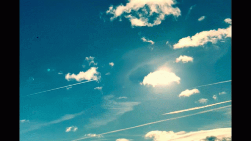 the sun shining down on clouds with planes flying overhead