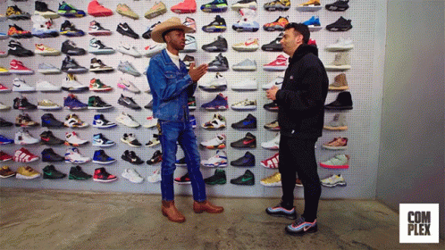 two guys are talking in front of a display of shoe shoes