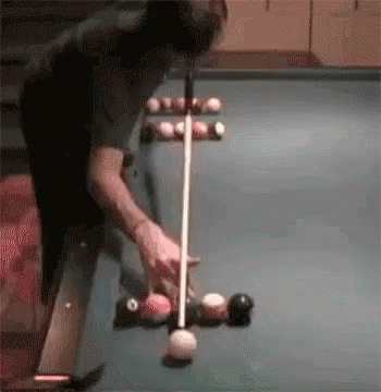 two balls are playing billiard with one ball going through the hole