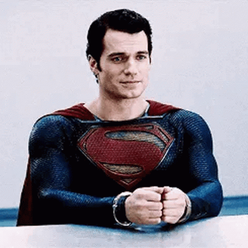 a man sitting down in supermans uniform