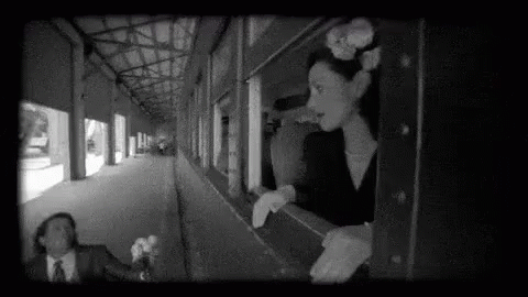 a black and white po shows people looking out the windows of a train