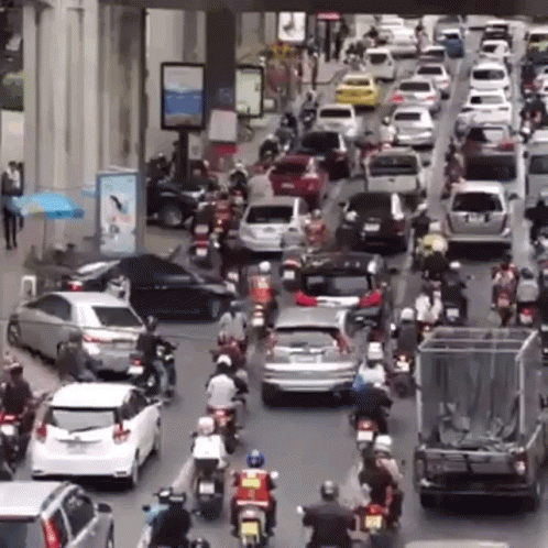 an image of cars and motorcycles in heavy traffic