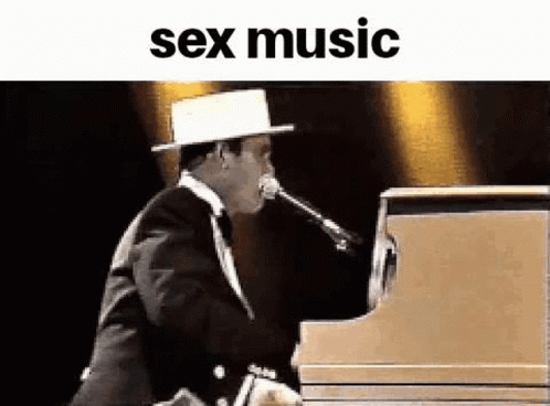 a man wearing a top hat, playing a piano