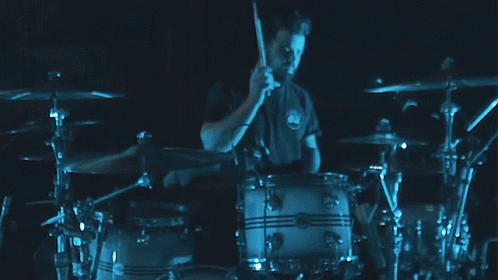 a drummer on the drums in front of some drums