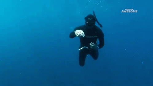 a man floating in the water wearing a scuba suit
