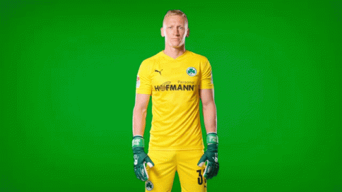 a man wearing gloves standing in front of a green background