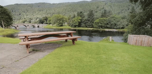 a blue picnic bench sitting near a river