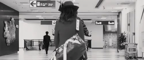 woman holding her hand in the air carrying her suitcase