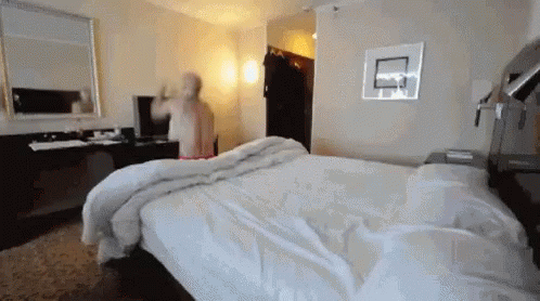 blurry image of bed and person looking in the mirror