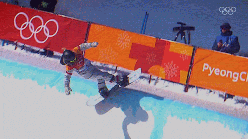 a man riding a snowboard on top of a ramp