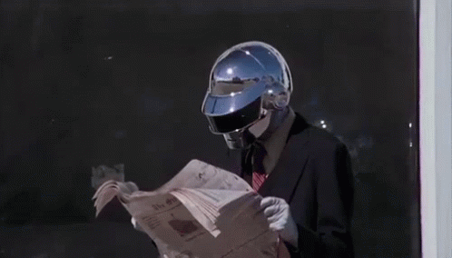 a man dressed in a suit and helmet reading a newspaper