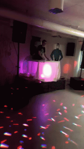 a blurry pograph of people in a ballroom with speakers and lights
