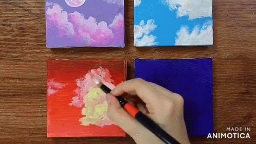 someone painting a piece of paper with acrylic paint on it
