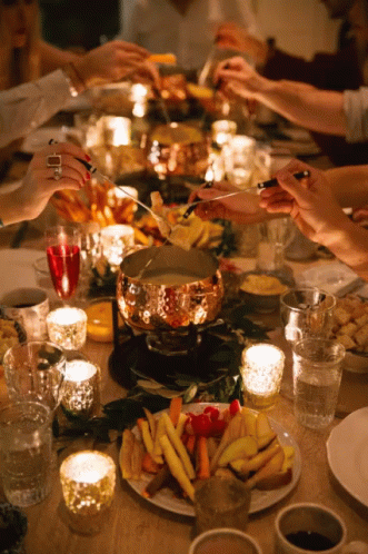 a long table with candle lit and plates of food