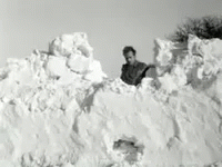 there is a man standing on a pile of snow