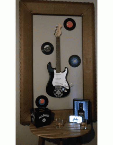 a blue table with a guitar and record collection on it