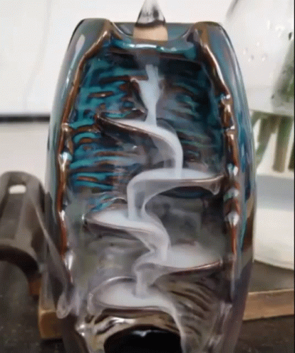 a glass vase sitting on a table with metal feet