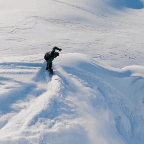 a person in snow gear climbing through the snow