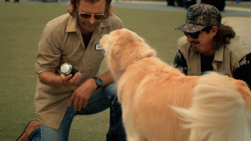 the man has his hand on the dog's collar