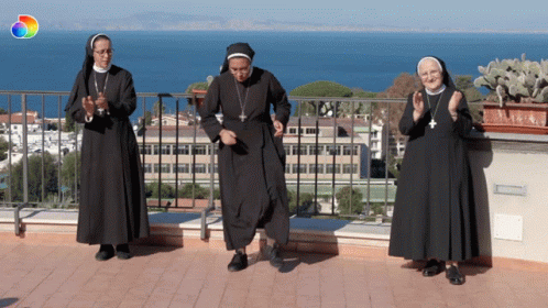 a group of people in nun costumes stand next to each other on a balcony