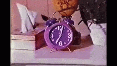 an old red alarm clock on a table