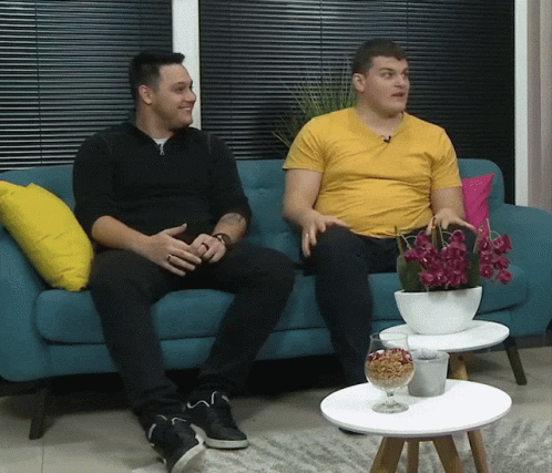 a picture of two men sitting on a couch