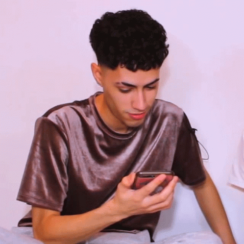 a boy in a grey shirt and a gray collar is holding his cell phone