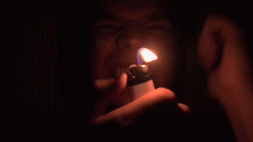a man holding a lighter up to the camera