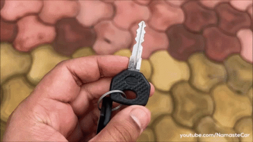 a hand holding up a tiny key to someone's keys